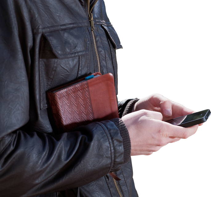 person in leather jacket with phone and bible